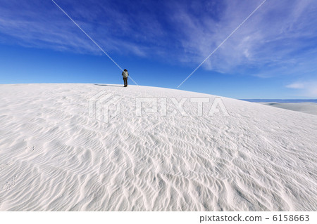 Photographer walking on white sands dunes 6158663