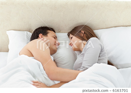 Tranquil couple looking at each other on their bed Tranquil couple looking at each other on their bed 6163701