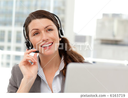 Thoughtful businesswoman talking on the phone while working on h 6163719