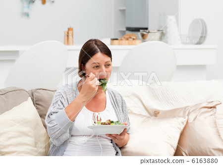 Pregnant woman eating vegetables Pregnant woman eating vegetables 6163880