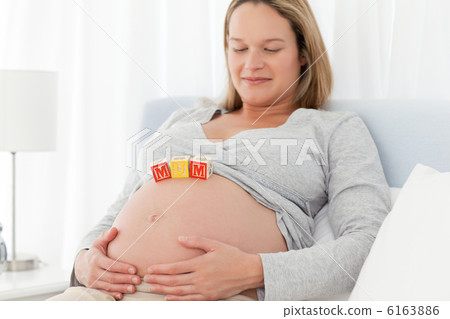 Relaxed woman looking at mom letters on her belly 6163886