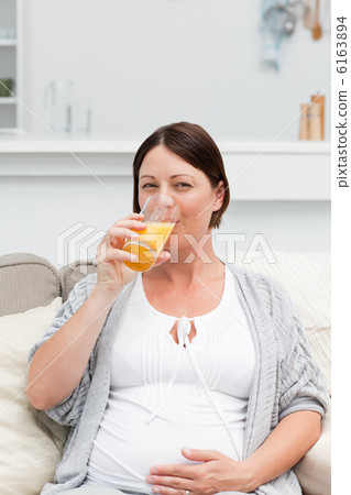 Pregnant woman drinking oranje juice Pregnant woman drinking oranje juice 6163894