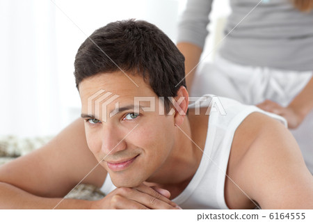 Portrait of a happy man being massaged by his girlfriend Portrait of a happy man being massaged by his girlfriend 6164555