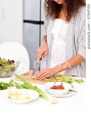 Close up of a woman cutting vegetables in the kitchen Close up of a woman cutting vegetables in the kitchen 6164560