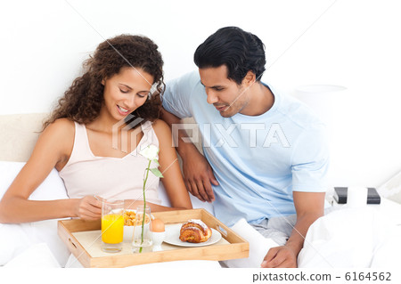 Cute woman eating cereals for breakfast lying on her bed Cute woman eating cereals for breakfast lying on her bed 6164562