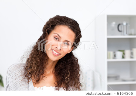 Portrait of a pretty woman standing in her kitchen Portrait of a pretty woman standing in her kitchen 6164566
