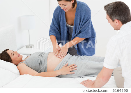 Pregnant woman with her husband and a nurse Pregnant woman with her husband and a nurse 6164590