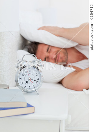 A irritate man in his bed before waking up 6164713