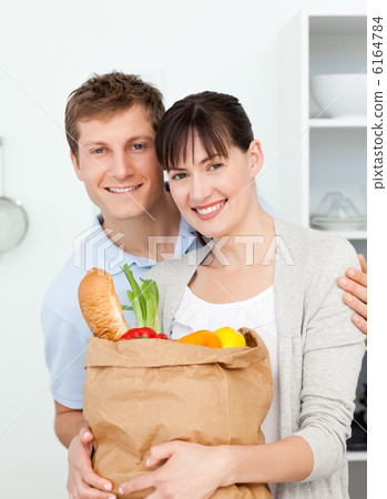 Lovely couple looking at the camera with their shoping bags 6164784