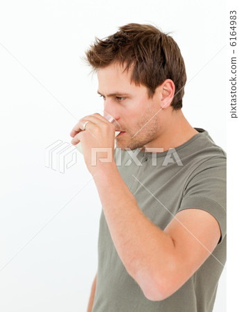 Handsome drinking milk standing in the kitchen 6164983