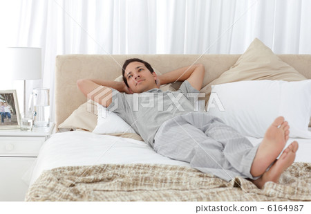 Tranquil man lying on his bed Tranquil man lying on his bed 6164987