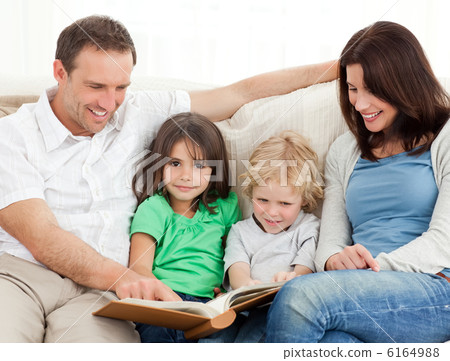 Cute girl and her family looking at a photo album Cute girl and her family looking at a photo album 6164988