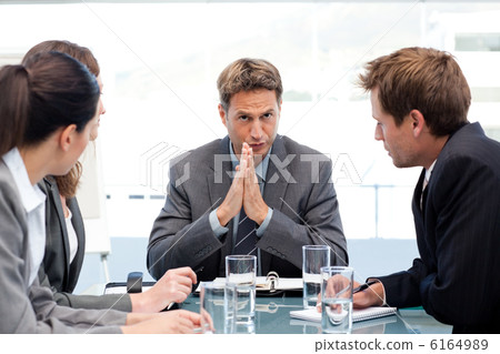 Serious manager talking to his team during a meeting 6164989