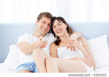 Smiling couple watching tv at home 6165355