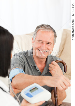 Nurse taking blood pressure of her patient 6165435