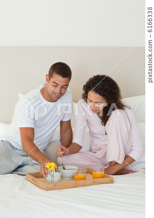 Couple having breakfast in their bed at home Couple having breakfast in their bed at home 6166338
