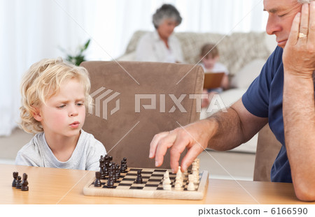 Young boy playing chess with his grandfather Young boy playing chess with his grandfather 6166590