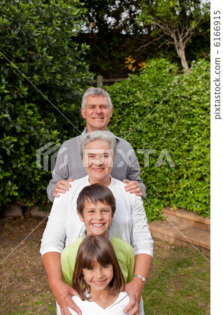 Grandparents with their grandchildren looking at the camera 6166915