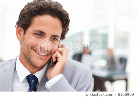 Charming businessman phoning in his office 6166969