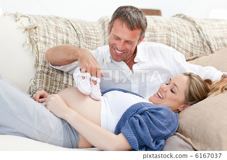 Lovers playing with childrens shoes at home Lovers playing with childrens shoes at home 6167037