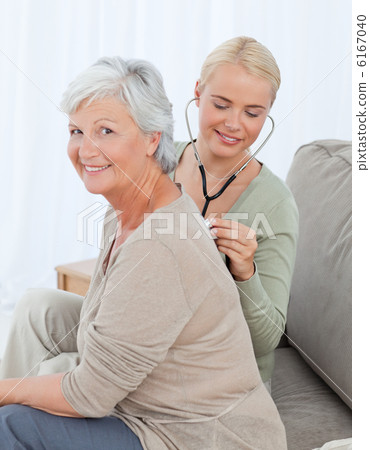 Nurse taking the heartbreat of her patient at home 6167040