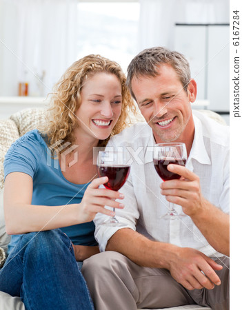 Couple drinking some red wine in the living room Couple drinking some red wine in the living room 6167284