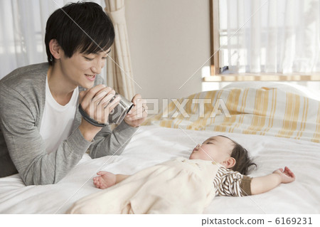 父親用攝像機拍攝嬰兒的睡覺臉 父親用攝像機拍攝嬰兒的睡覺臉 6169231