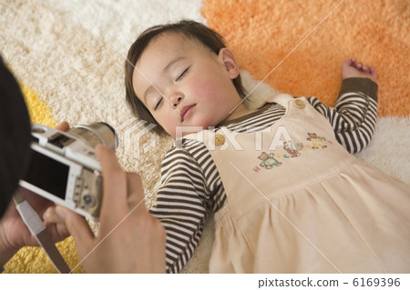 A father taking a baby's sleeping face with a digital camera A father taking a baby's sleeping face with a digital camera 6169396