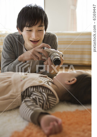 A father taking a baby's sleeping face with a digital camera A father taking a baby's sleeping face with a digital camera 6169447