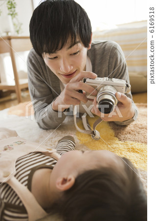 A father taking a baby's sleeping face with a digital camera A father taking a baby's sleeping face with a digital camera 6169518