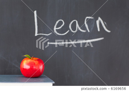 Stack of books with a red apple and a blackboard with "learn" wr Stack of books with a red apple and a blackboard with "learn" wr 6169656