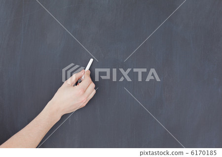 Hand holding a chalk and and ready to write on a blackboard 6170185