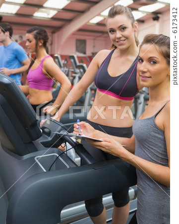 Happy woman and instructor in the gym 6173412