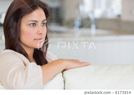 Woman on sofa looking thoughtful 6173914