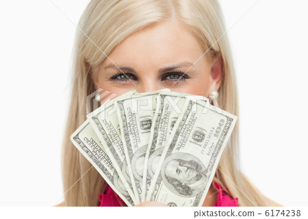 Smiling blonde hiding her face with 100 dollars banknotes 6174238