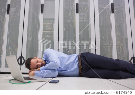 Man sleeping while doing maintenance on servers Man sleeping while doing maintenance on servers 6174540