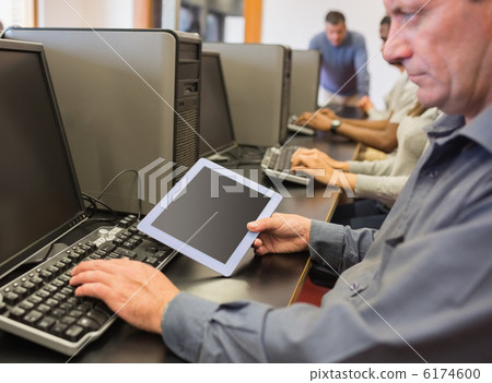 Man in computer class looking at tablet pc 6174600