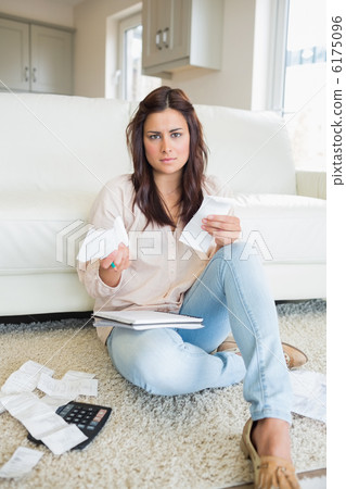 Young woman looking worried over bills 6175096