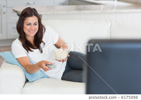 Brunette changing channel on tv 6175098