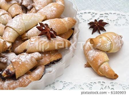 Freshly baked croissants with powdered sugar. 6180903