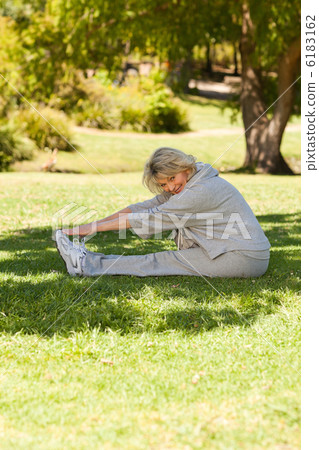 Mature woman doing her streches in the park Mature woman doing her streches in the park 6183162