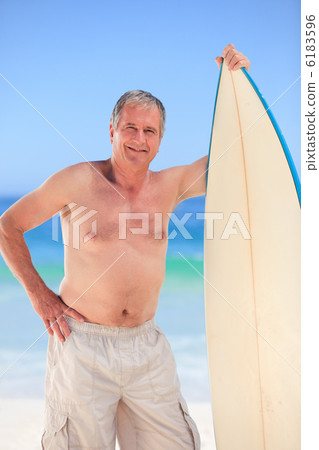 Mature man with his surfboard 6183596