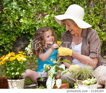 Happy Grandmother with her granddaughter working in the garden 6184269
