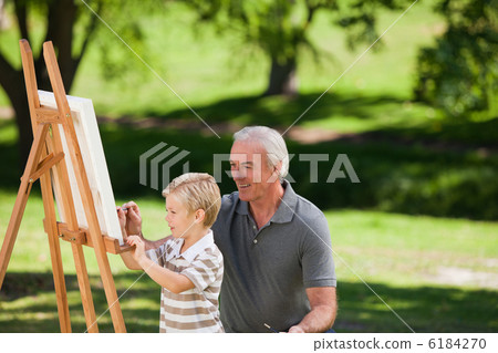 Grandfather and his grandson painting in the garden Grandfather and his grandson painting in the garden 6184270