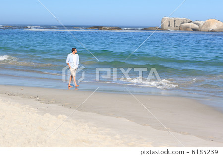 Man walking on the beach Man walking on the beach 6185239