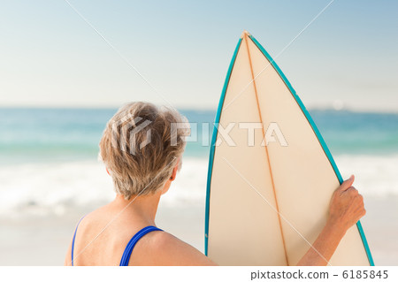 Woman with her surfboard at the beach 6185845