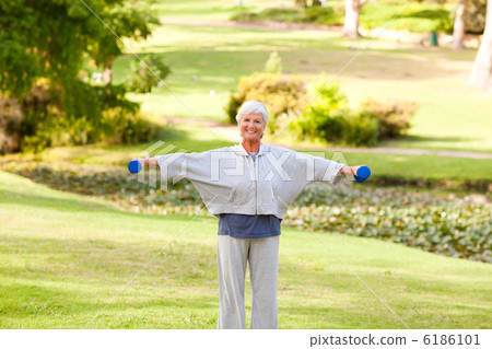 Mature woman doing her exercises in the park 6186101