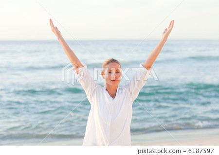 Active woman practicing yoga on the beach Active woman practicing yoga on the beach 6187597