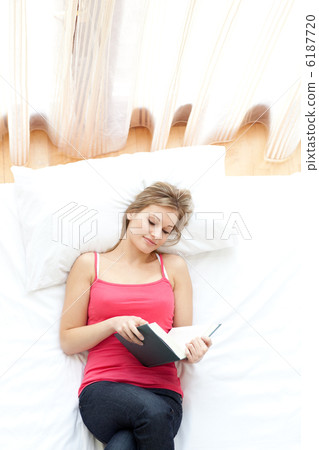 Relaxed woman reading on her bed Relaxed woman reading on her bed 6187720