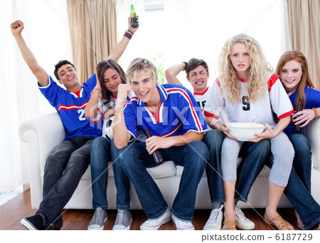 Teenagers watching a football match at home Teenagers watching a football match at home 6187729